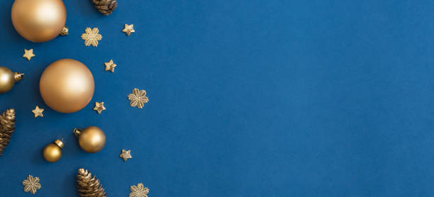 istock Christmas holiday banner background with copyspace. Flat lay frame with christmas balls and decorations on a blue background 1346938978