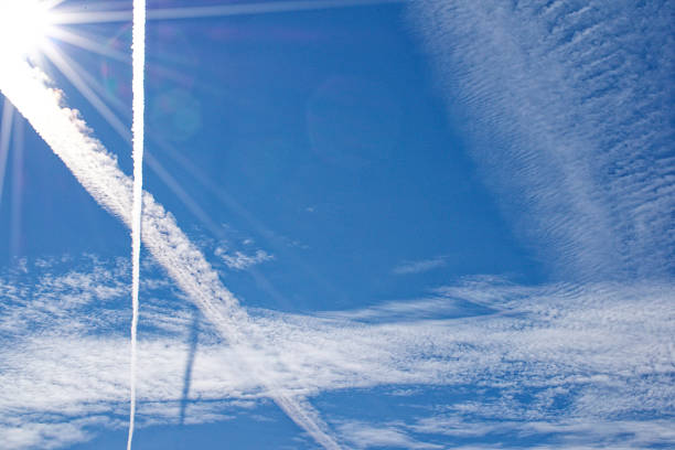 istock Blue sky with clouds and airplane trails in Ventspils, Latvia. 1346938990