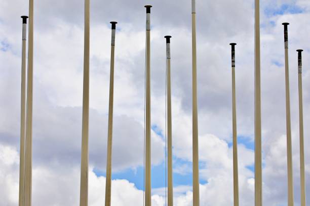 Empty flagpoles in front of a cloud sky