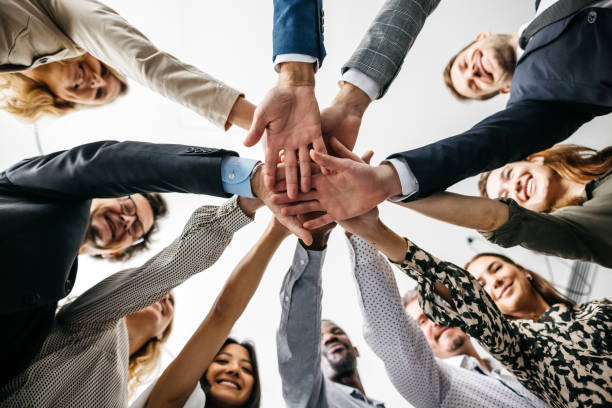 istock Low-angle close-up of co-workers putting hands together 1346944003