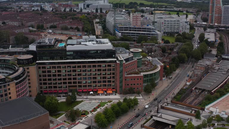 Aerial view of modern Television centre building. Trains standing in White City train station. London, UK