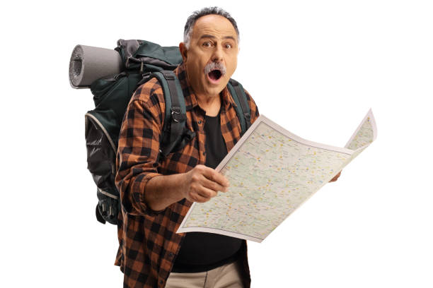 excursionista maduro sorprendido sosteniendo un mapa y mirando a la cámara - tourist map men holding fotografías e imágenes de stock