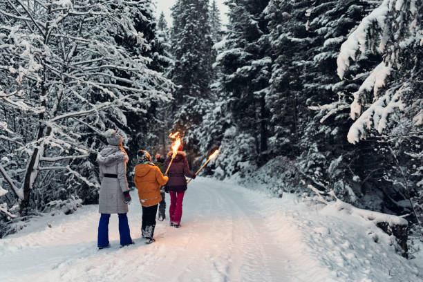 istock Family walking in winter forest with torches 1346950880
