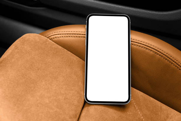 istock Smartphone in a car use for navigate or GPS. Driving a car with smartphone. Mobile phone with isolated white screen on brown perforated lether seat. Copy space. Empty space for text. 1346952642
