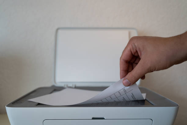 istock Hand puts paper in the printer to copy it 1346956606