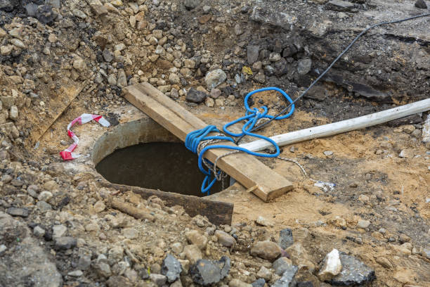 istock Open sewer manhole, wooden plank and rope 1346957871