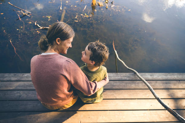 istock Mother and son relaxing at a lake 1346957952
