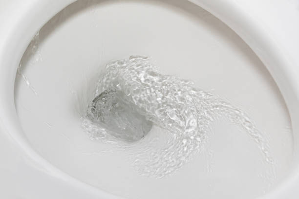 Motion blur of flushing water in toilet bowl. Plumbing, home repair and water conservation concept. stock photo