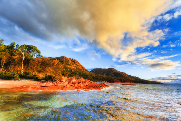 Tas Coles bay light shore range Honeymoon bay on Coles bay of Tasmanian east coast at colourful sunset near Freycinet peninsula. honeymoon bay stock pictures, royalty-free photos & images