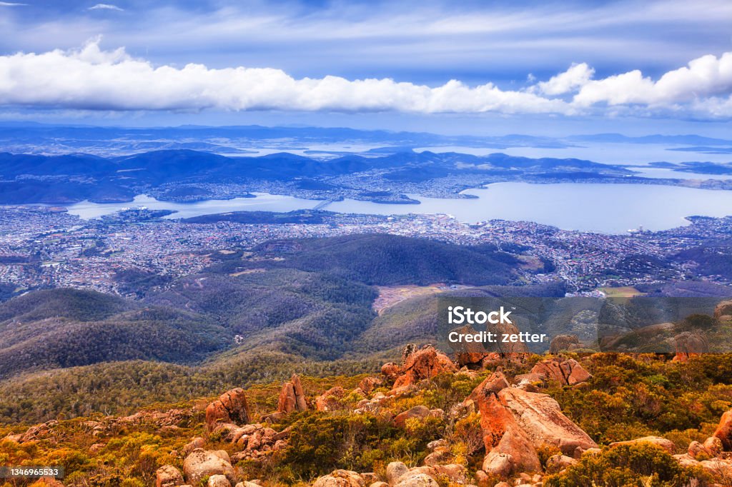 Tas Mt Wellington Rocks Hobart Aerial view over Hobart city from lookout of Mt Wellington at the level with clouds - rough terrain blown by winds. Tasmania Stock Photo