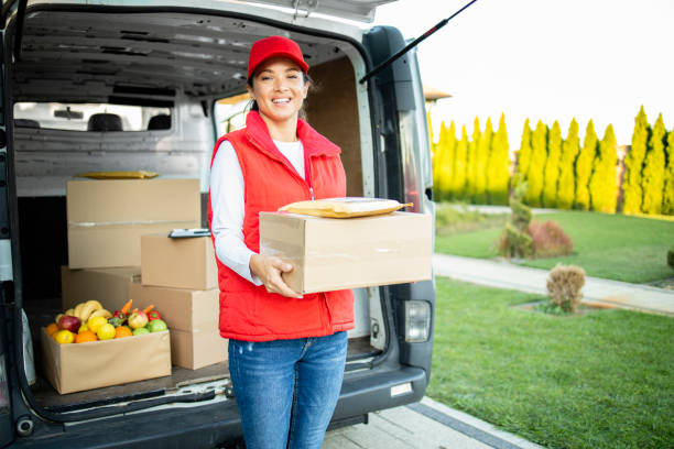 istock Portrait of hardworking female courier holding package before delivery. 1346972429