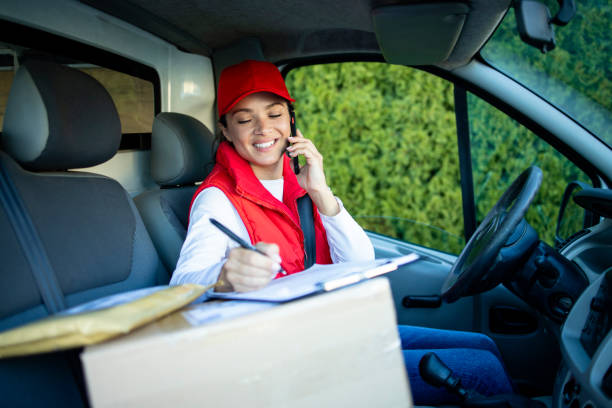 istock Female courier in delivering van talking on the phone. 1346972506