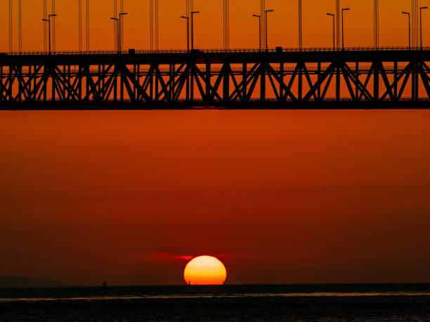 sonnenuntergang und akashi kaikyo brücke - kobe bridge japan suspension bridge stock-fotos und bilder