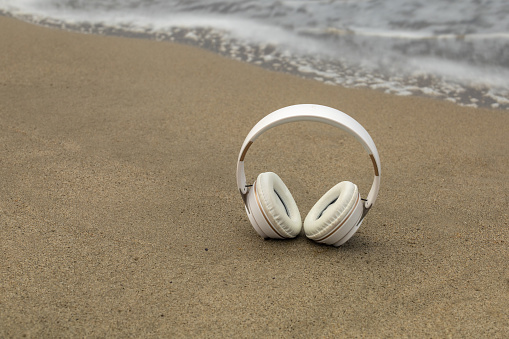 wireless helmets located on the shore of the beach with waves of the sea and copy space concept relaxation tranquility
