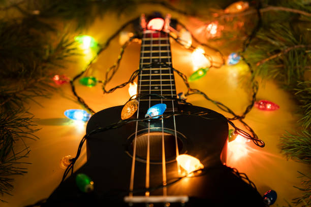 musikinstrument auf dunklem hintergrund. e-gitarre mit beleuchteter girlande auf dunklem hintergrund. geschenk gitarre klassische formen für weihnachten, neujahr. neujahrs- und weihnachtsmusik, konzept - guitar classical music classical style jazz stock-fotos und bilder