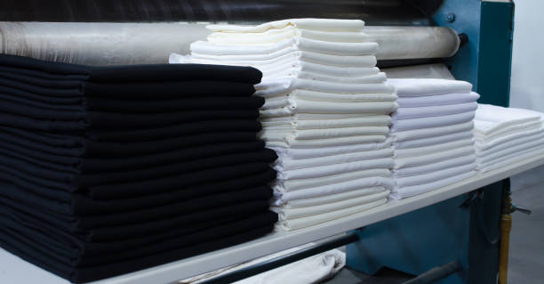 istock Stack of folded black and white cloths in an industrial laundry. 1346987408