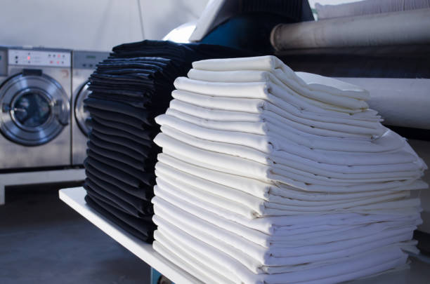 stack of folded black and white cloths in an industrial laundry. - lavar roupa imagens e fotografias de stock