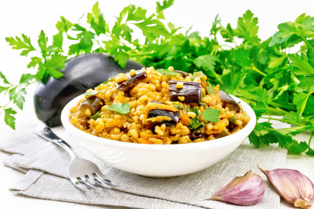 istock Bulgur with eggplant in bowl on wooden board 1346996688
