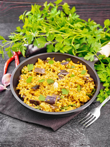 istock Bulgur with eggplant in pan on wooden board 1346996689
