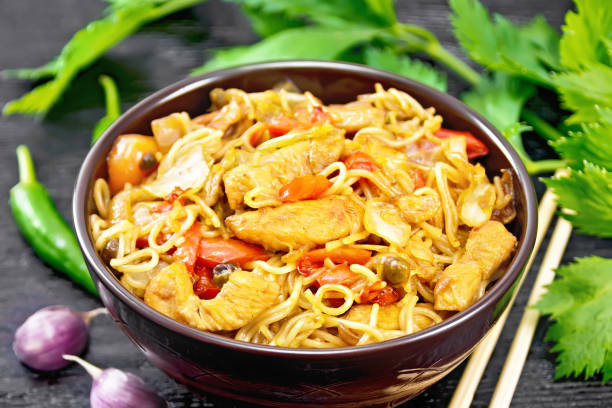 istock Noodles with cabbage and chicken in bowl on black board 1346998061