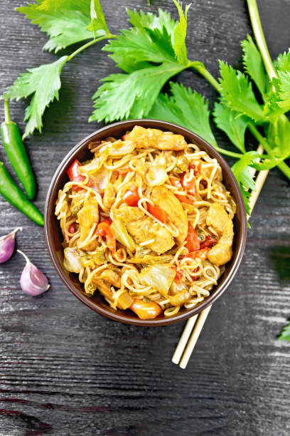 istock Noodles with cabbage and chicken in bowl on black board top 1346998065