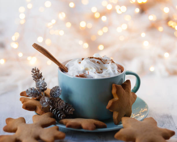 istock Winter hot drink: blue mug with hot chocolate with marshmallow and cinnamon. Cozy home atmosphere, festive holiday mood. Rustic style, wooden background. Homemade gingerbread cookies, dry orange 1347000080
