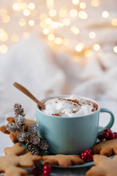 istock Winter hot drink: blue mug with hot chocolate with marshmallow and cinnamon. Cozy home atmosphere, festive holiday mood. Rustic style, wooden background. Homemade gingerbread cookies, dry orange 1347000100