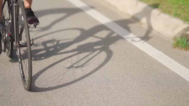 shadow of asian chinese couple cyclist  road biking cycling during weekend morning together