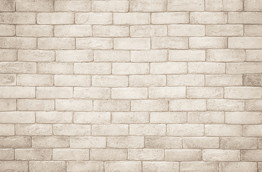 Cream and white brick wall texture background. Brickwork and stonework flooring interior rock old pattern clean concrete grid uneven bricks design stack. Background of old vintage brick wall