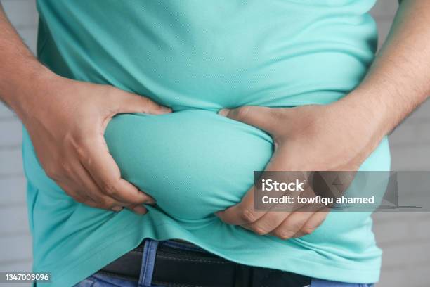 Mans Hand Holding Excessive Belly Fat Overweight Concept Stock Photo - Download Image Now