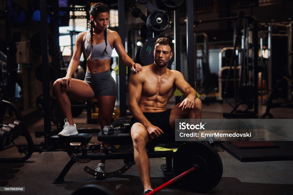 Young sporty fit Caucasian couple posing at the gym Abdominal Muscle Stock Photo
