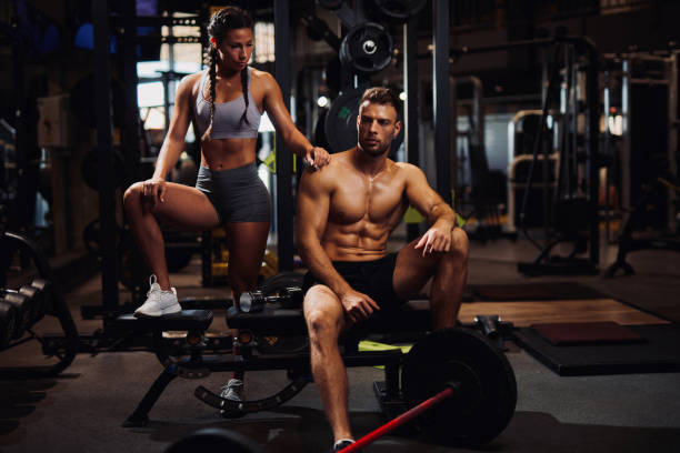 Young sporty fit Caucasian couple posing at the gym stock photo
