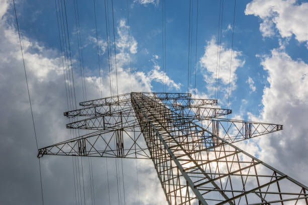 istock Power pole and power lines with blue sky and first thunderclouds in the background 1347004740