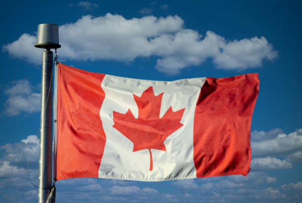 istock A Waving Canadian flag with a blue sky with clouds 1347005781