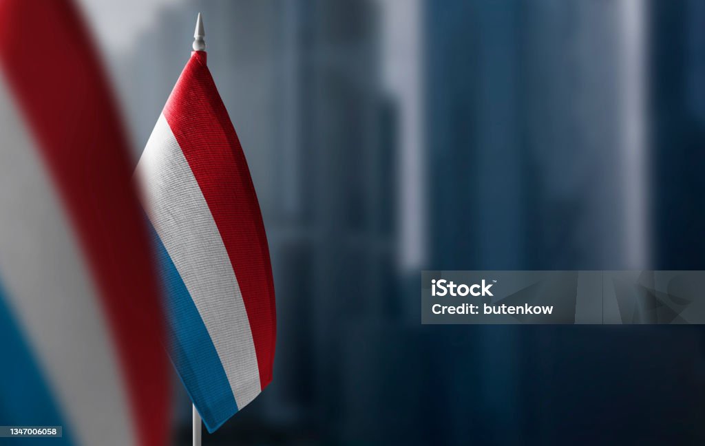 Small flags of Luxembourg on a blurry background of the city Small flags of Luxembourg on a blurry background of the city. Luxembourg City - Luxembourg Stock Photo