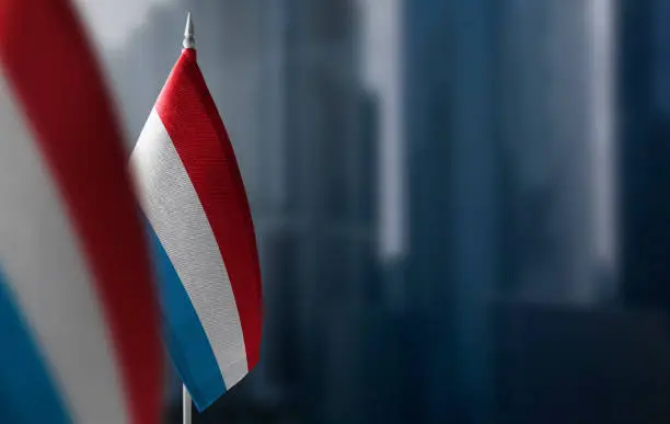 Small flags of Luxembourg on a blurry background of the city.