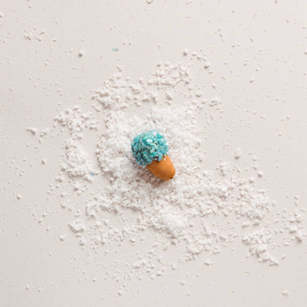 Acorn seed in blue stone glitter texture laying down on snow. Aesthetic layout.