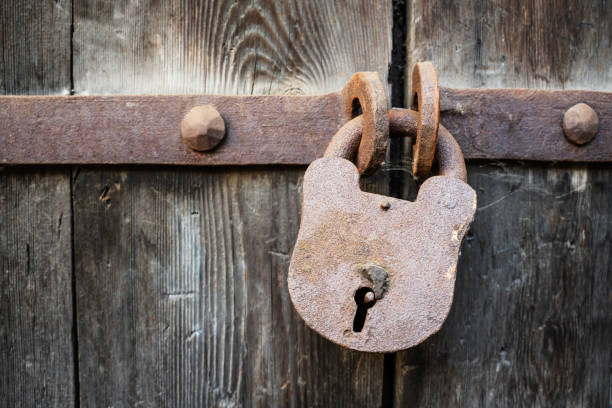 istock Old rusty padlock closes a wooden door or gate 1347010357