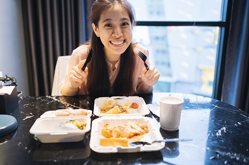 Generation Z asian female enjoy eating steak dinning home take away and delivering food with recycle packaging