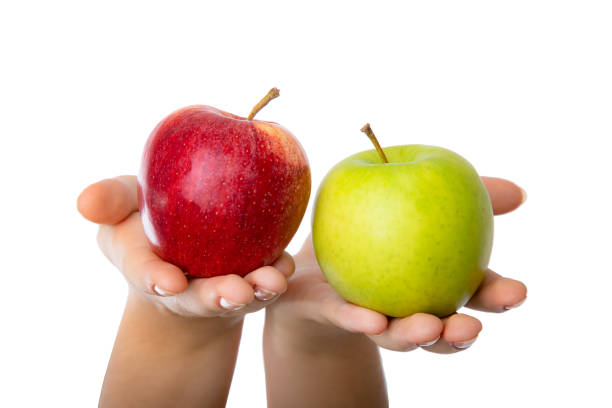 istock Red and green apple held in female hands. 1347013453