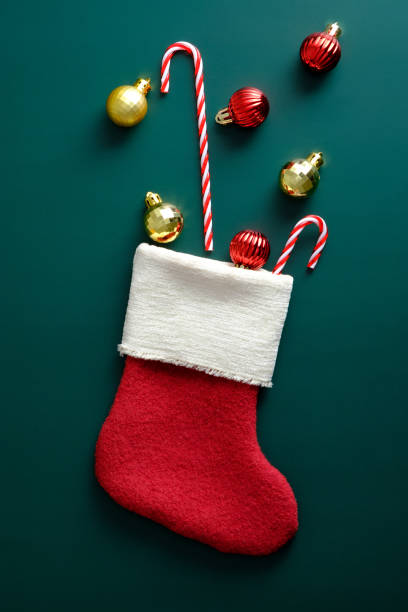 istock Christmas stocking with decorations and candy canes on dark green background. 1347019949