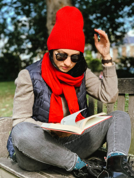 istock Young woman is reading book in a park 1347021580