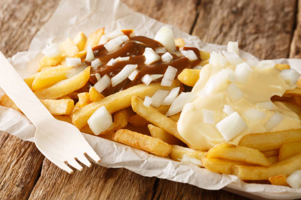Patatje oorlog is a Dutch street food dish consisting of fries topped with a mayonnaise, finely chopped onions and peanut sauce closeup in the plate. Horizontal Patatje oorlog is a Dutch street food dish consisting of fries topped with a mayonnaise, finely chopped onions and peanut sauce closeup in the plate on the table. Horizontal finely stock pictures, royalty-free photos & images