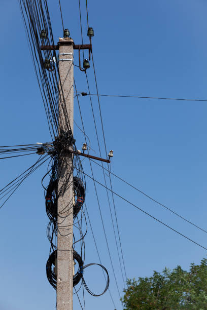 istock Tangled electric cables on concrete post. Blue sky, selective focus, vertical orientation 1347024711