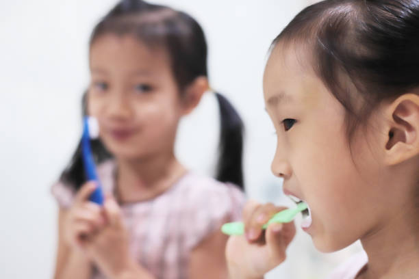 istock asian girls brushing teeth. 1347025335