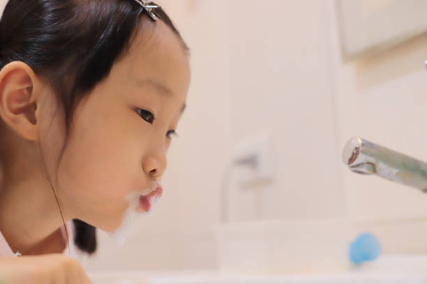 istock asian girl brushing teeth. 1347025404