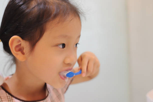 istock asian girl brushing teeth. 1347025438
