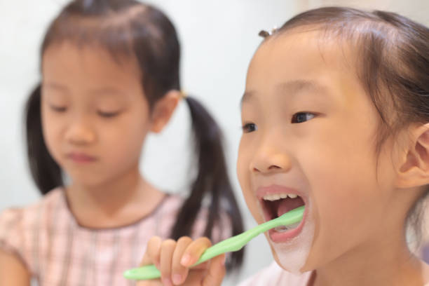 istock asian girls brushing teeth. 1347025468