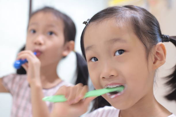 istock asian girls brushing teeth. 1347025478
