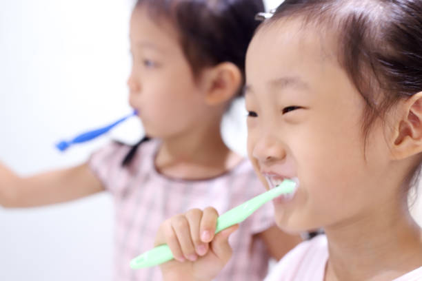 istock asian girls brushing teeth. 1347025491